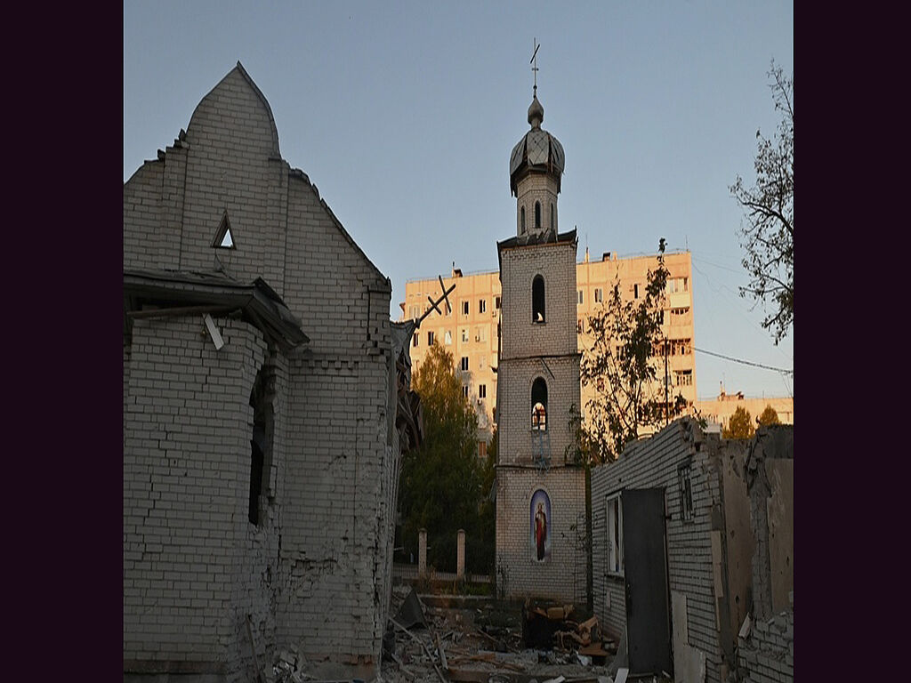 The temple is damaged after the missile attack. Windows are blown out in the back of a high-rise building 