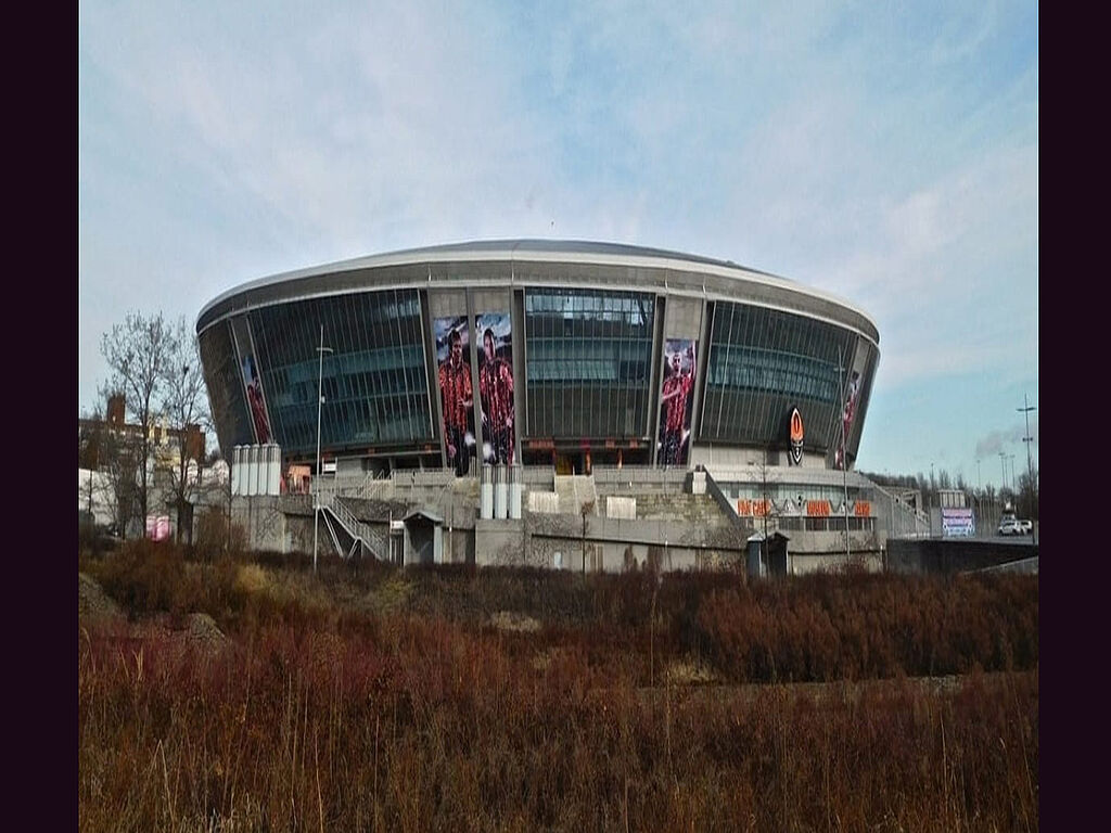 A view of the facade. All overgrown with weeds, no landscaping