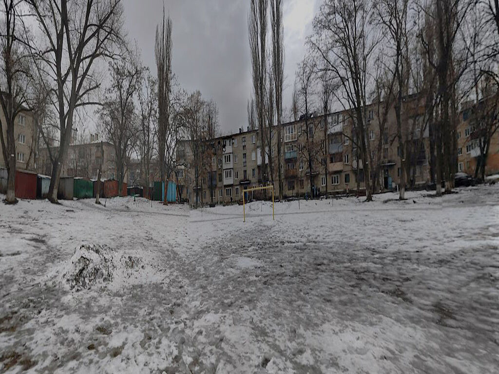 The sports ground of the school, with nearby residential buildings visible