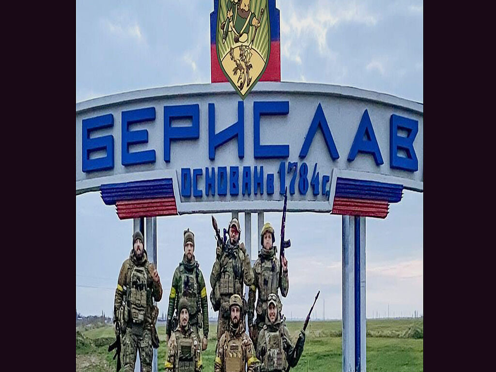 Soldats des forces armées ukrainiennes près de la stèle de la ville repeinte par les Russes. En ce moment, les troupes russes quittent la région de Kherson